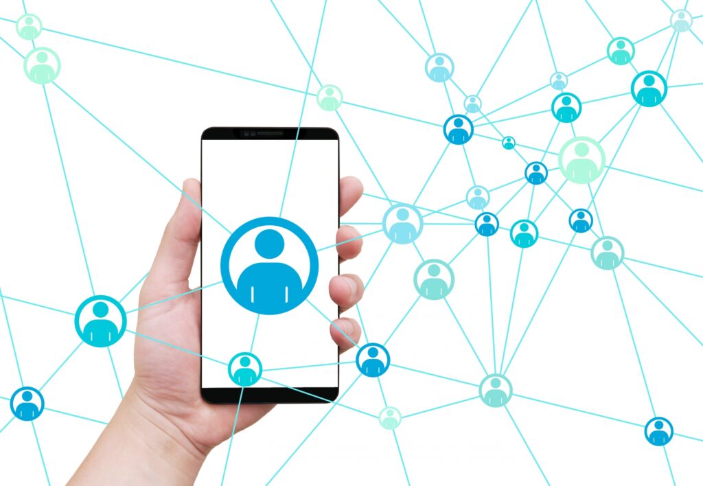 SNSとスマホ。背景に多くの人がつながっている。