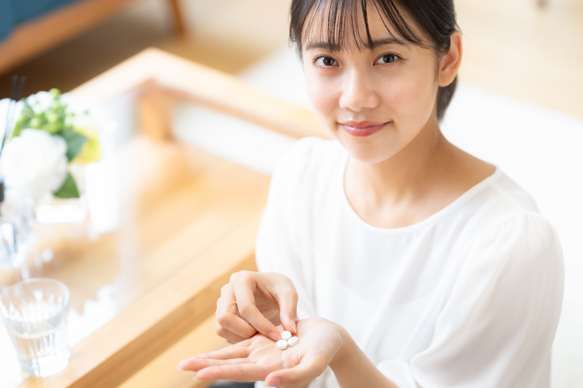 錠剤を手にのせている女性